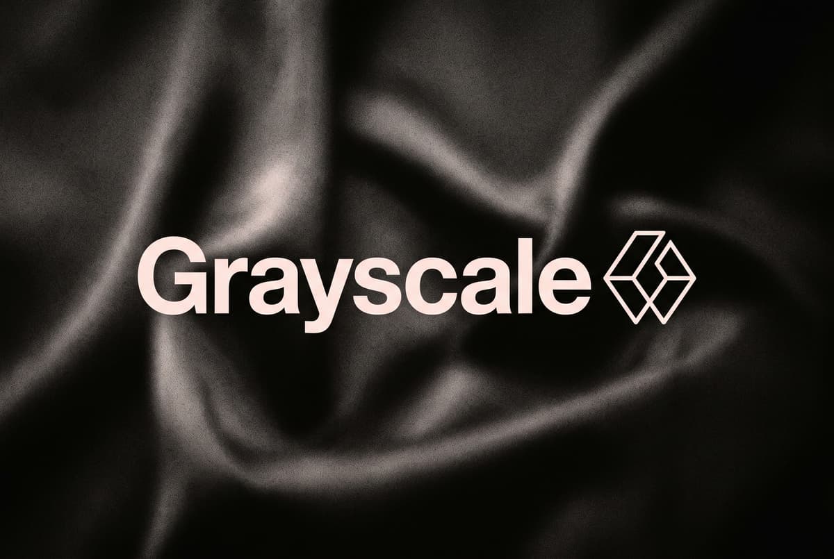 The name Grayscale in large pale letters beside its logo, centred over soft dark folds of silk.
