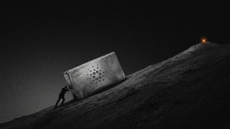 A small silhouette strains to push a large copper ingot bearing the Cardano mark up a steep slope toward a distant summit.