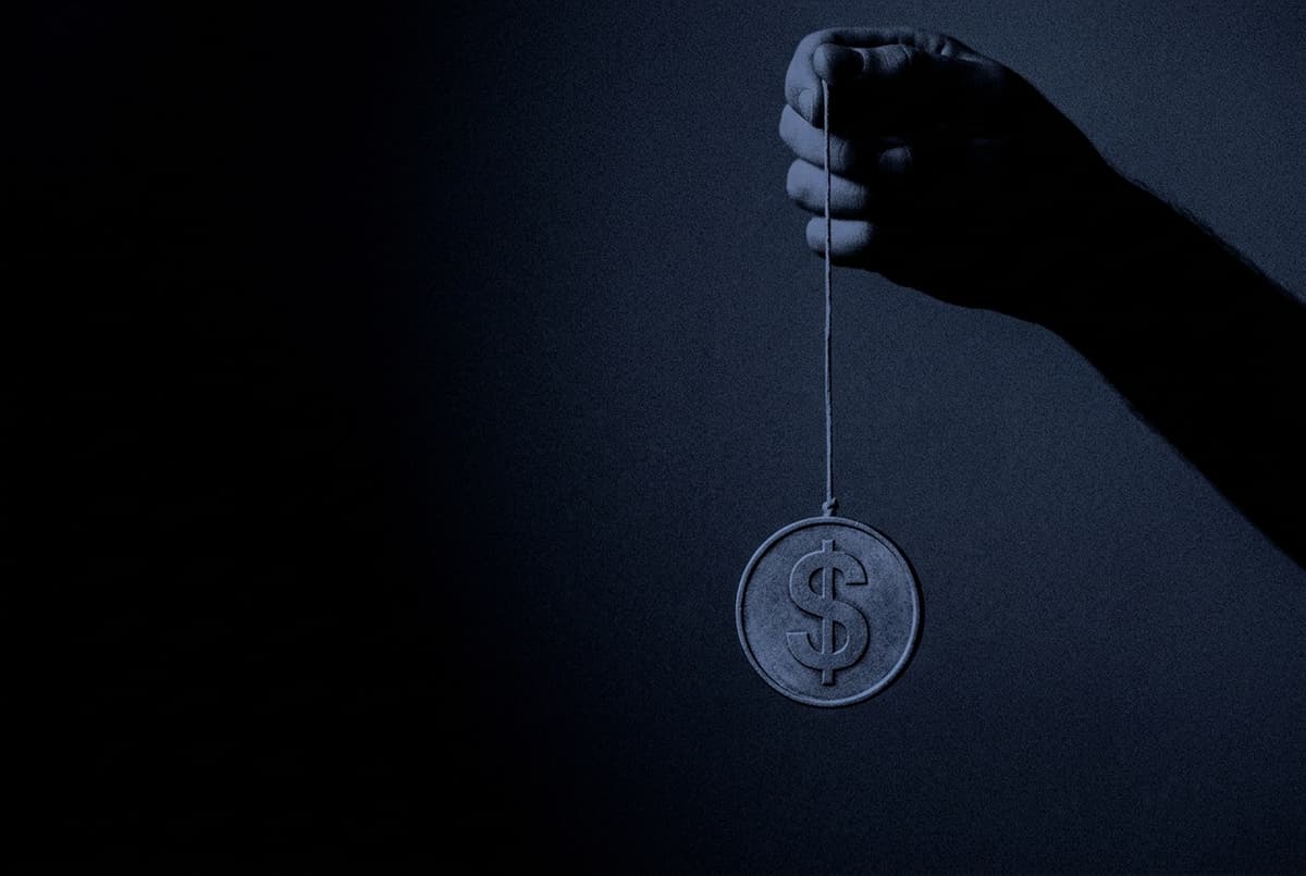 A giant hand holds a string with a dollar coin hanging from it like a yo-yo, pulled back up against a dark background.